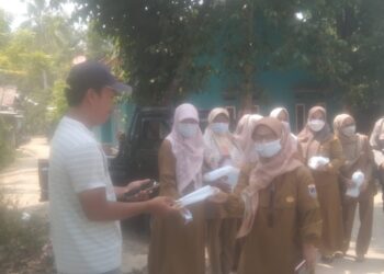 Antisipasi Dampak Abu Vulkanik Krakatau, Desa Karyawangi Bersama Bhabinkamtibmas Door to Door Bagikan Masker ke Warga